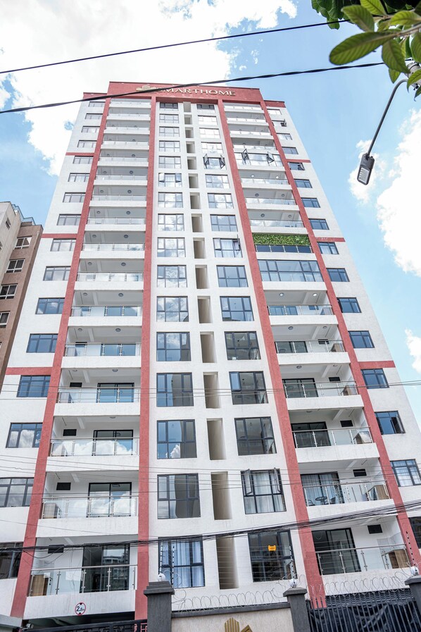 A multi-story building with a red and white facade, balconies, and a visible sign reading "MARTHOME". - Maskan Suites (Nairobi)