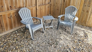 A wooden fence, two Adirondack chairs, and a small table with a metal frame. - 2BD-RemoteWork-Extd Stay Discounts-PetsOK-Central (Corpus Christi)