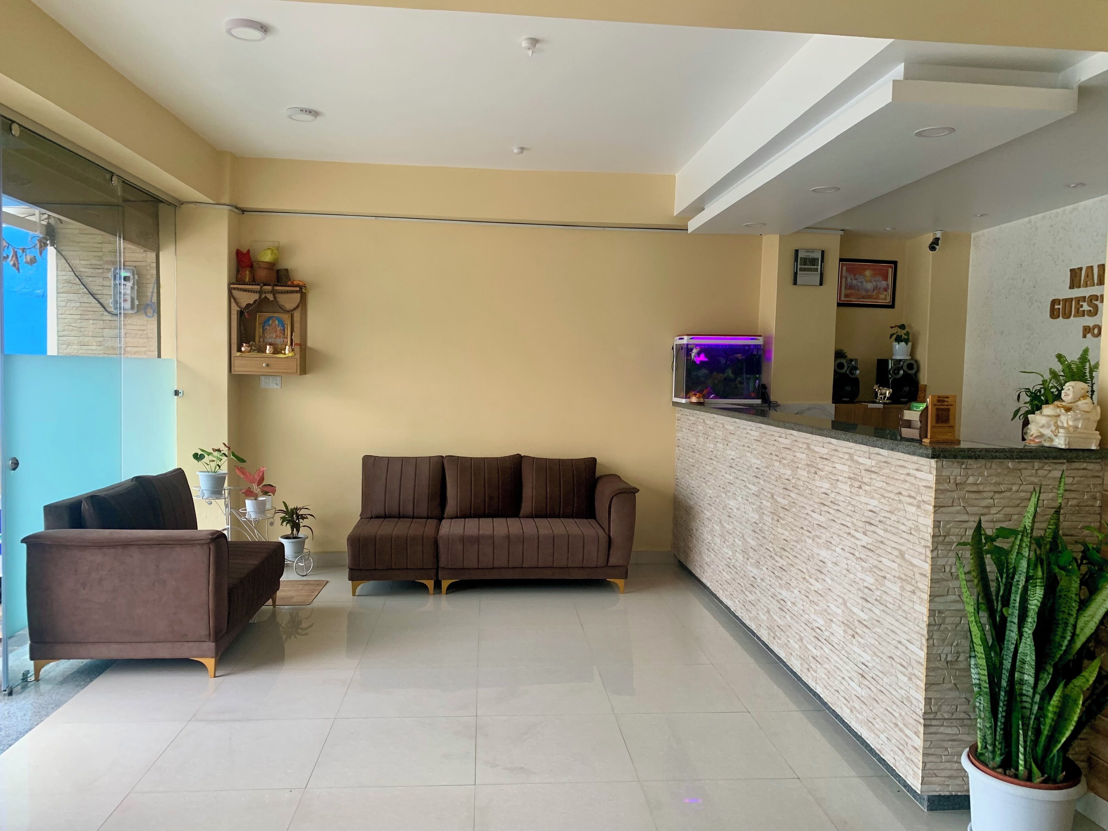 A modern reception area with a sofa, a coffee table, and a potted plant.