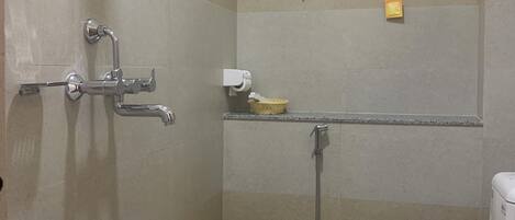 A small bathroom with a toilet, sink, shower, and grab bars.