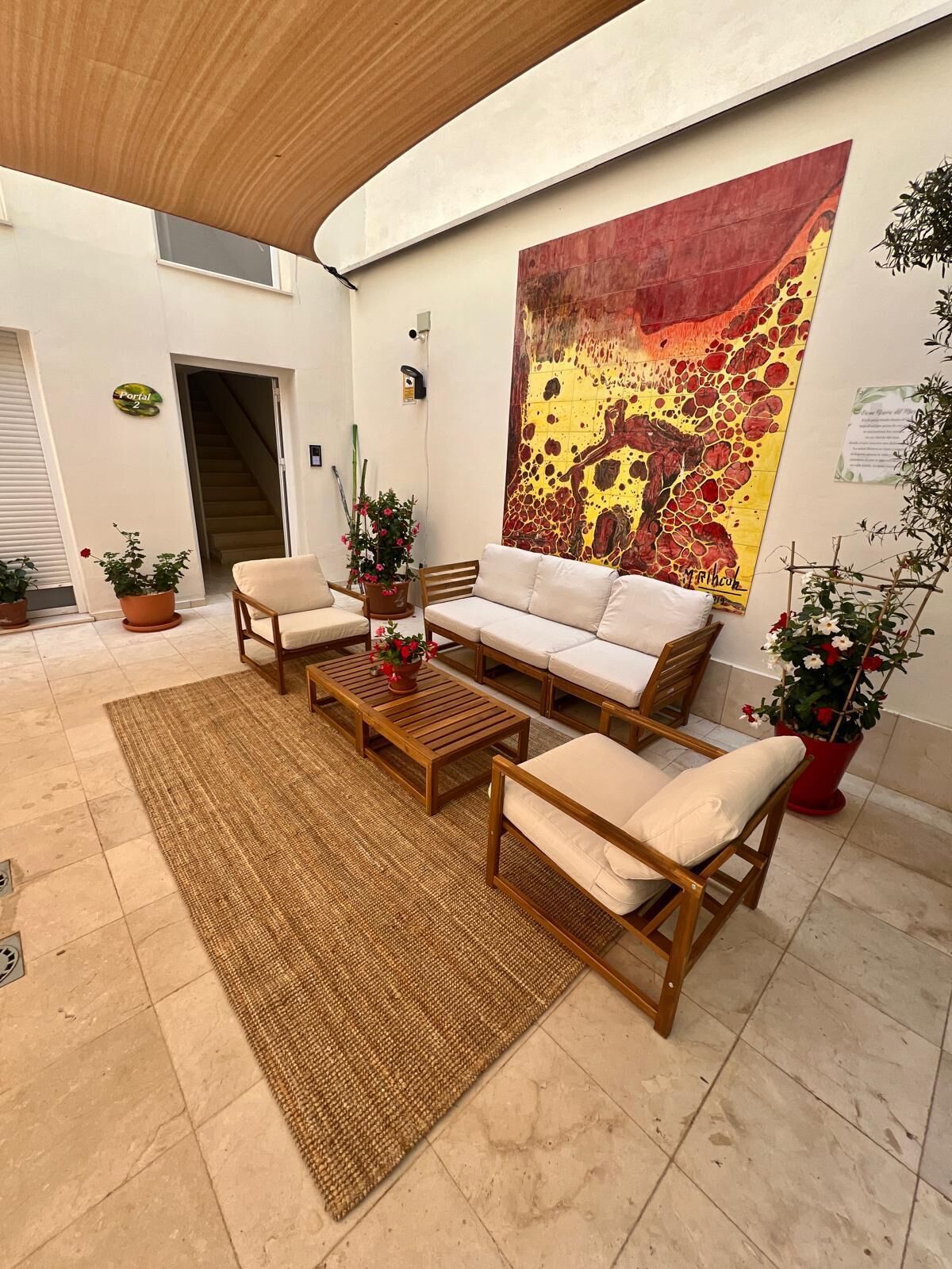 A spacious indoor area with a sofa set, a coffee table, and potted plants.