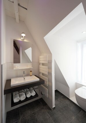 A modern bathroom with a white sink, mirror, and towel rack. - Les Maisons du pont - Charme & Caractère (Aubusson)