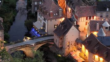 Eine historische Stadt mit einer Steinbrücke, traditionellen Gebäuden und einem Fluss.
