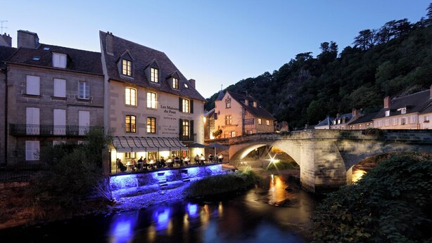 A stone bridge over a river with buildings on either side, including a restaurant named "Les Maisons du Pont". - Les Maisons du pont - Charme & Caractère (Aubusson)