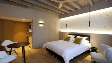 Une chambre moderne avec un grand lit, une table à manger et un ventilateur de plafond.