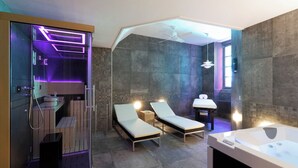 A modern bathroom with a glass-enclosed shower, two lounge chairs, a bathtub, and a large mirror. - Les Maisons du pont - Charme & Caractère (Aubusson)