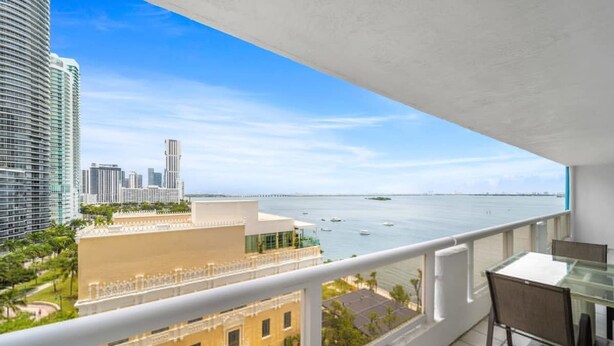 A balcony with a view of the ocean and city skyline. - Florida Sunrise Pool Hot Tub (Miami)