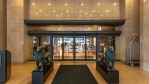 A hotel entrance with a glass door, two lion statues, and a tiled floor. - Florida Sunrise Pool Hot Tub (Miami)