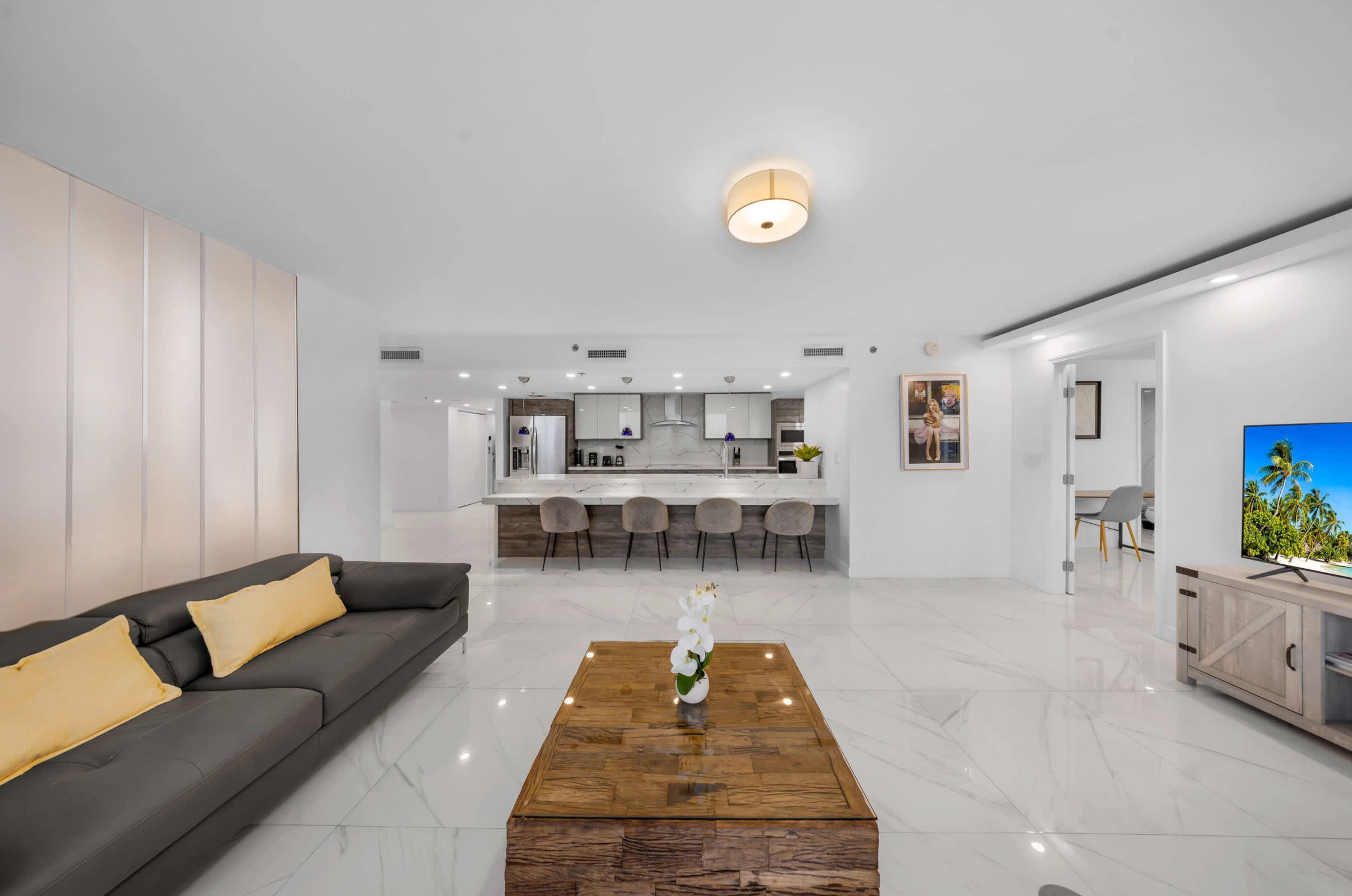 A modern living room with a sofa, coffee table, and a TV on a wooden cabinet.