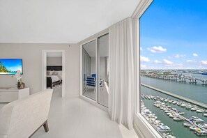 A modern hotel room with a large balcony, a view of a marina, and a dining area with a view of the water. - Azure Skies High Floor (Miami)