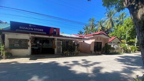 Una vetrina con l'insegna del negozio Rizalyn Store che pubblicizza una stanza in affitto.