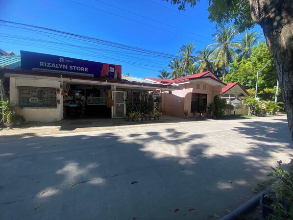 A storefront named Rizalyn Store with a signboard advertising a room for rent.
