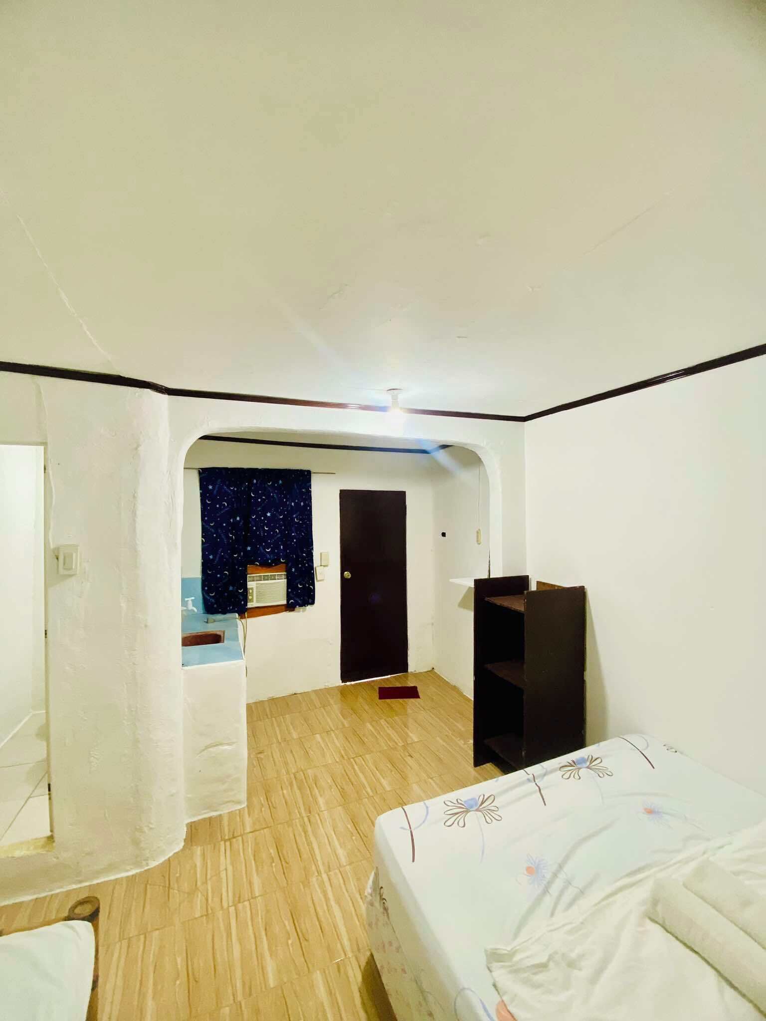 A room with a bed, a desk, and a window with a starry night view.