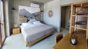 Un dormitorio con cama, mesita de noche, lámpara colgante y un armario de madera.