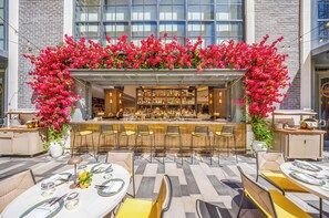An outdoor bar area with a bar counter, seating, and a floral arch. - Luxurious Miami Studio in DTW | Pool | Balcony (Miami)