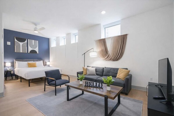 A modern living room with a bed, a sofa, a coffee table, and a television. - Cozy studio located in Louisville's prime location (Louisville)