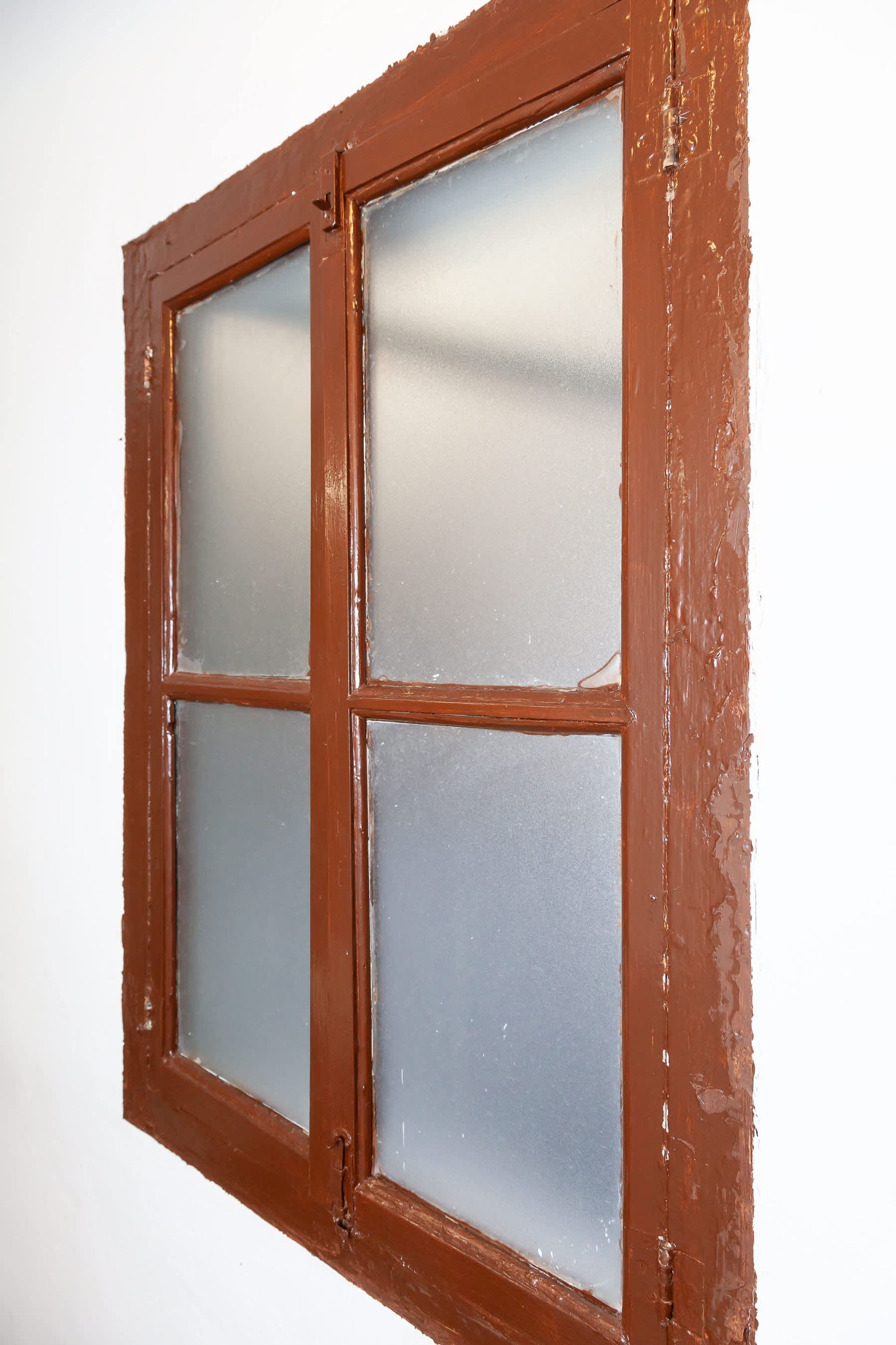 A window with a brown frame and frosted glass panes.