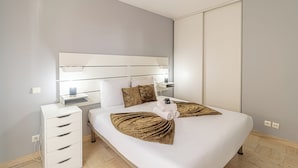 Een moderne hotelkamer met een groot bed, een nachtkastje en een inbouwkast.