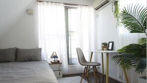 A bedroom with a bed, a desk, a chair, and a potted plant. - NEW OPEN 2 minutes walk from Higashi-Shinjuku Station (新宿区)
