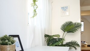A white desk with a remote control, a framed picture, and a potted plant. - NEW OPEN 2 minutes walk from Higashi-Shinjuku Station (新宿区)