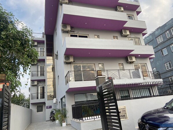 Un immeuble à plusieurs étages doté de balcons et de climatiseurs.
