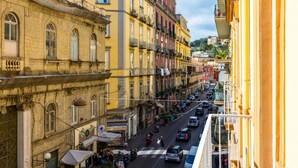 A street view of a European city with historic buildings, a pedestrian crossing, and cars on the road. - Maison Vittorio Emanuele (Naples)