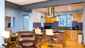 Una cocina moderna con salpicadero de azulejos azules, armarios de madera y una isla central.