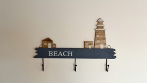 Une décoration murale en bois représentant le mot « PLAGE » et un paysage urbain.