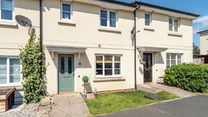 A two-story residential building with a front door, windows, and a satellite dish. - Stylish 3 bedroom house with parking and private garden. Ideal for families, groups or work stays. (Cheltenham)