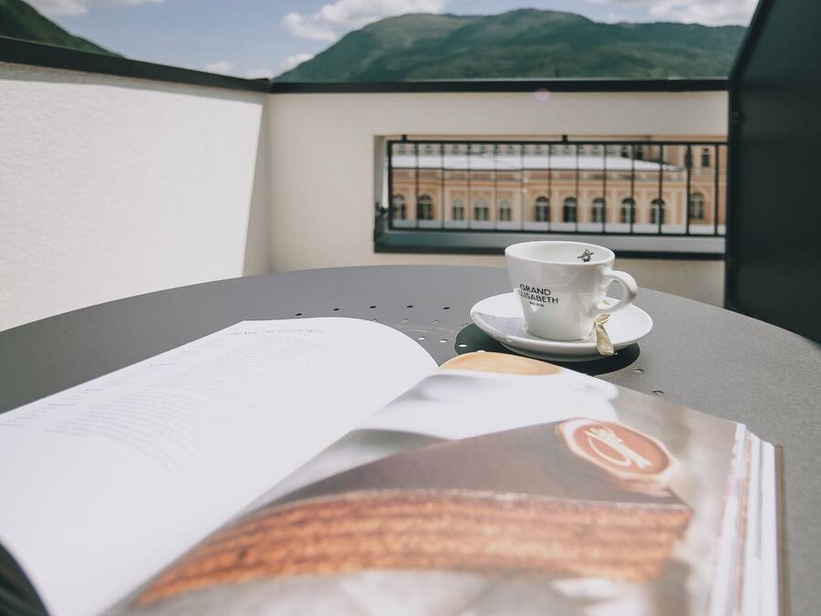 Una mesa con un libro, una taza de café y una revista.