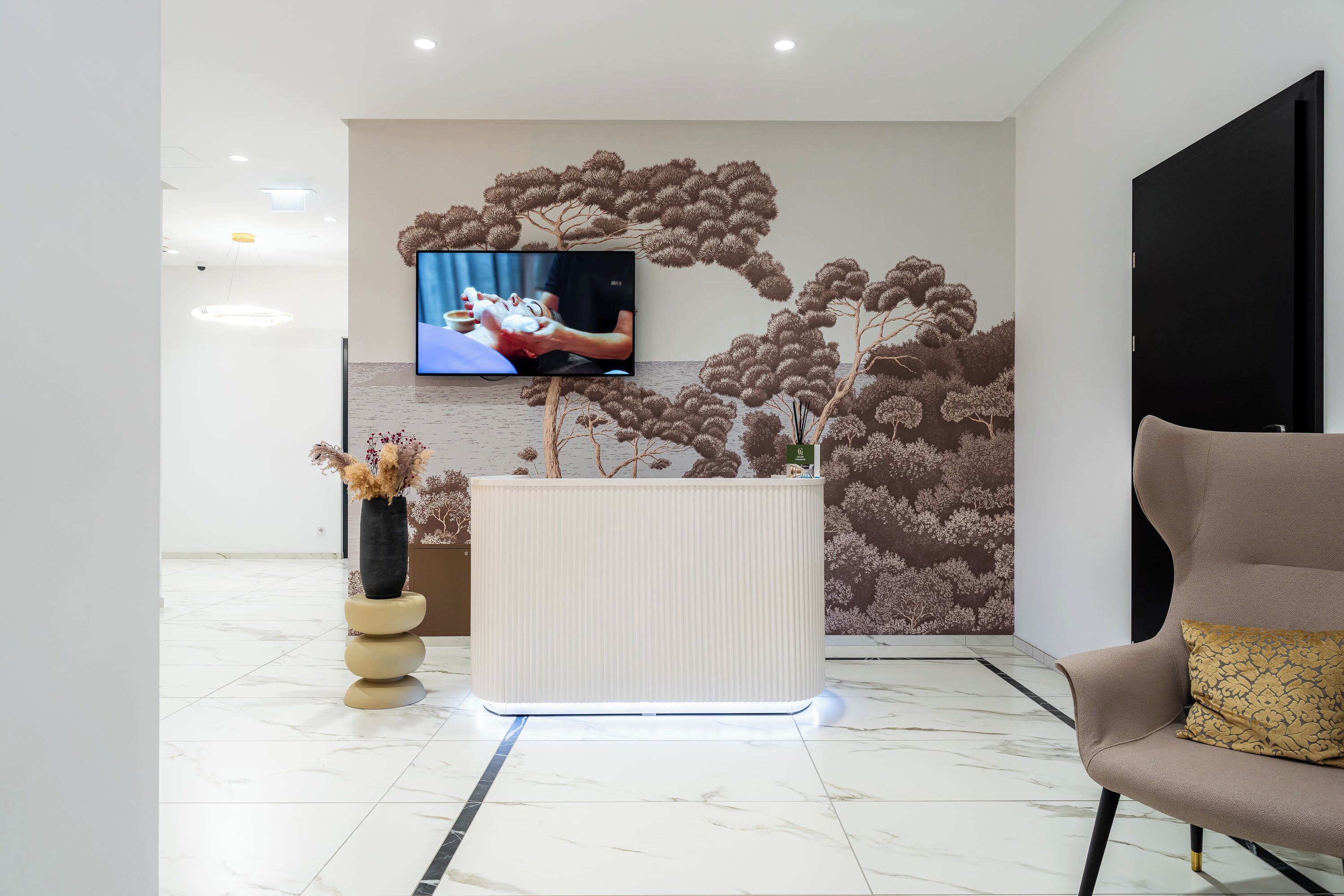 Un hall d’entrée moderne doté d’un comptoir de réception, d’un téléviseur à écran plat et d’un espace salon.