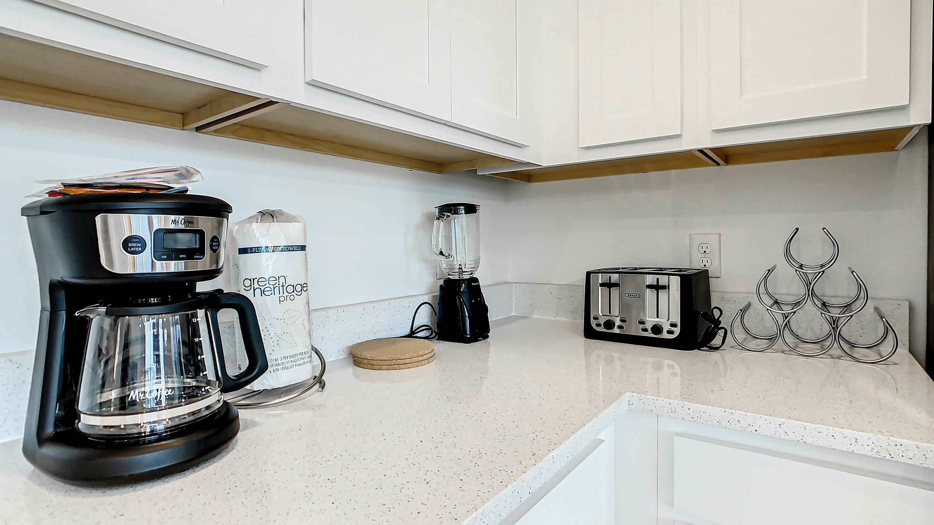 A kitchen with a coffee maker, a blender, and a toaster.
