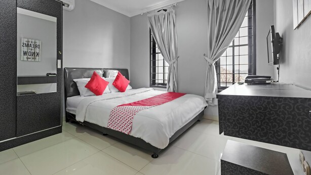 Quarto de hotel moderno com cama, escrivaninha e uma janela grande.
