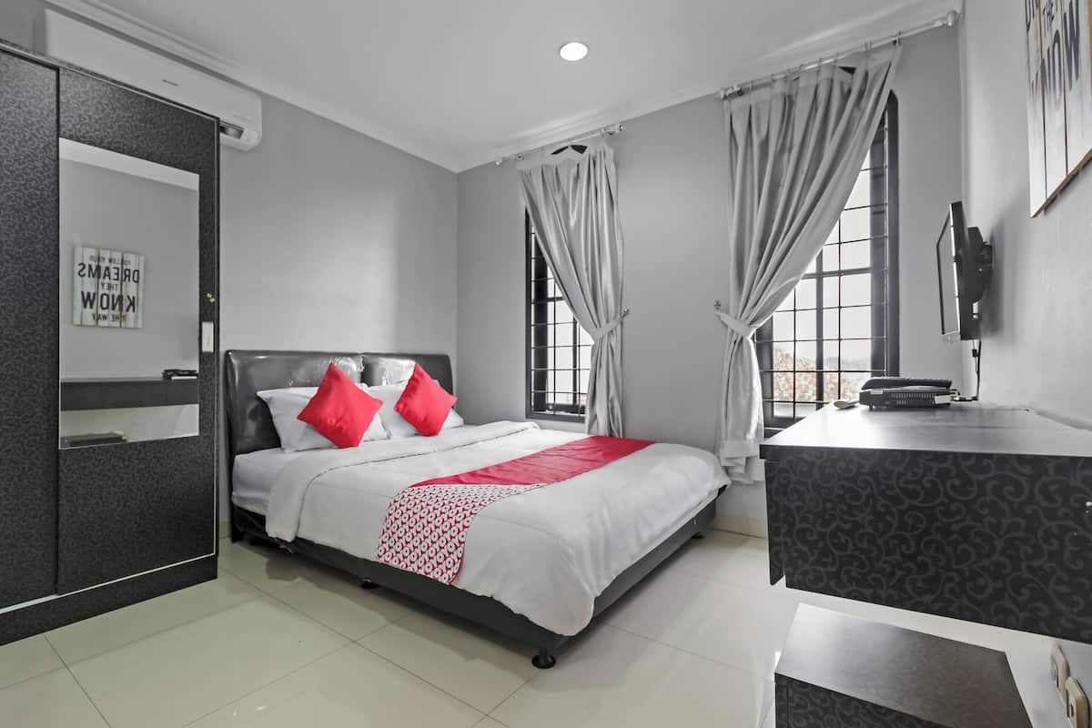 Una habitación de hotel moderna con cama, escritorio y un amplio ventanal.