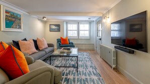 A living room with a sofa, coffee table, and a television.