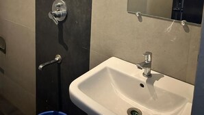 Ein Badezimmer mit einem weißen Waschbecken, einem Spiegel und einer Dusche.