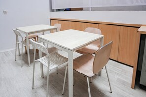 Enjoy meals in a clean and functional dining area with two tables and matching chairs.