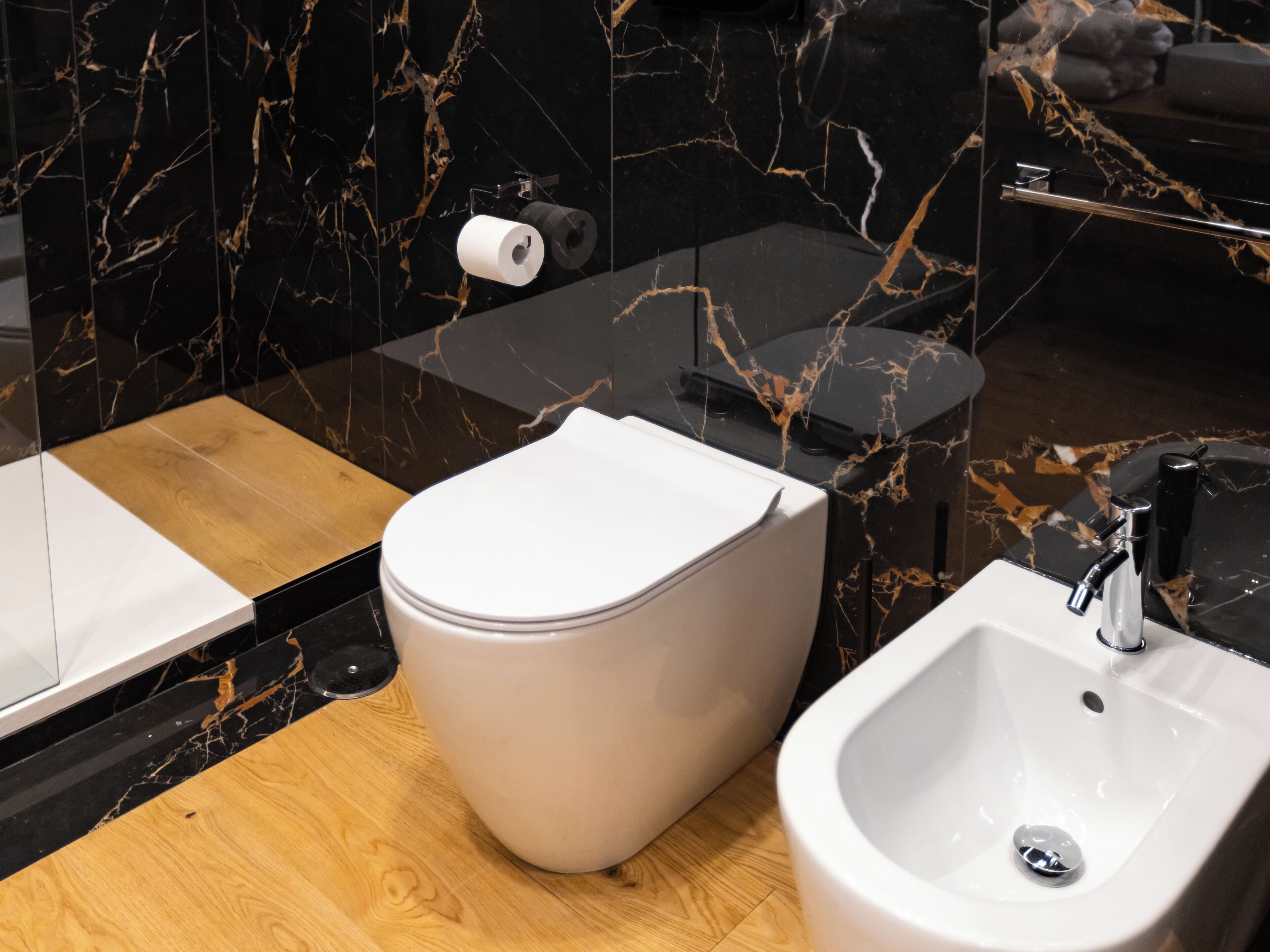 Une salle de bain moderne équipée de toilettes, d’un bidet et d’un lavabo.