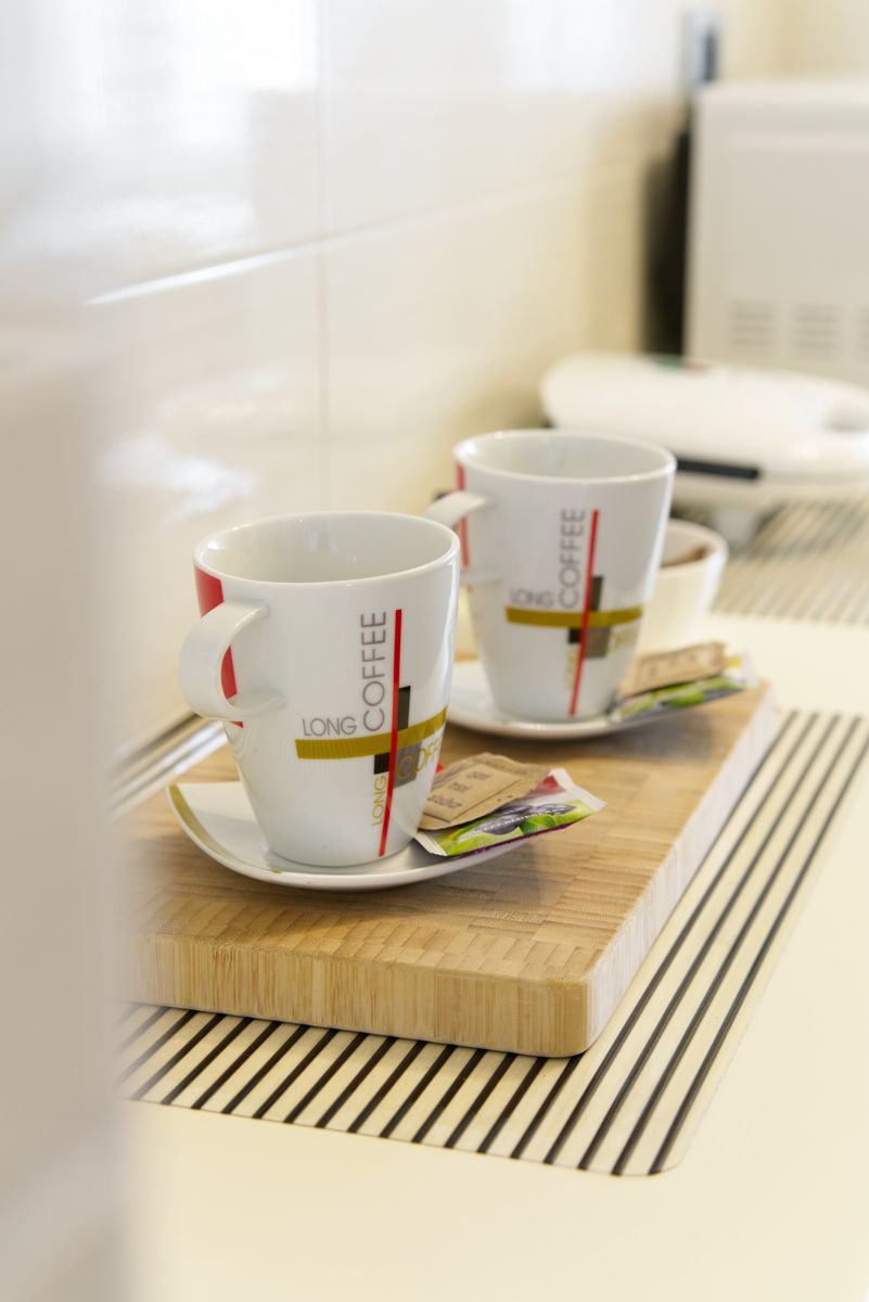 Two white coffee cups with red handles and "LONG COFFEE" text on a wooden tray.