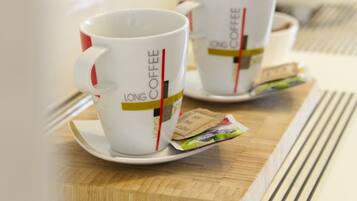 Two white coffee cups with red handles and "LONG COFFEE" text on a wooden tray.