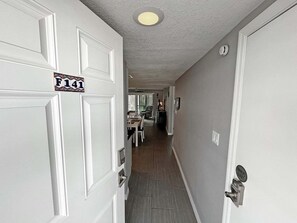 A hallway with white doors, a sign reading 'F141', and a 'OWNER'S CLOSET' sign.