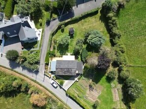 Eine Vogelperspektive eines Wohngebiets mit Häusern, einer Straße und umgebender Vegetation.