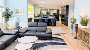 En moderne stue med sofa, sofabord og kig til køkkenet.