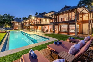 A modern house with a swimming pool, outdoor seating, and a well-maintained lawn. - Bluestone, Bluestone on Hamilton Island (Hamilton Island)