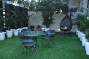 Relax in a serene outdoor space surrounded by lush greenery and comfortable seating.