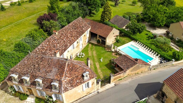 Un vaste domaine comprenant une piscine, plusieurs bâtiments et de vastes étendues de verdure.