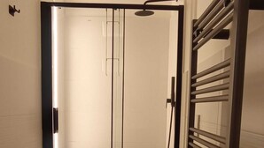 A modern bathroom with a shower, toilet, and a towel rack. - Mayflowers Apartment  - Biancospini (Milan)