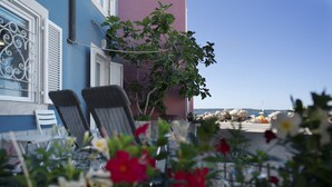 A terrace with two chairs, a table, and a view of the sea. - Punta Apartment KA 2.2 (Piran)