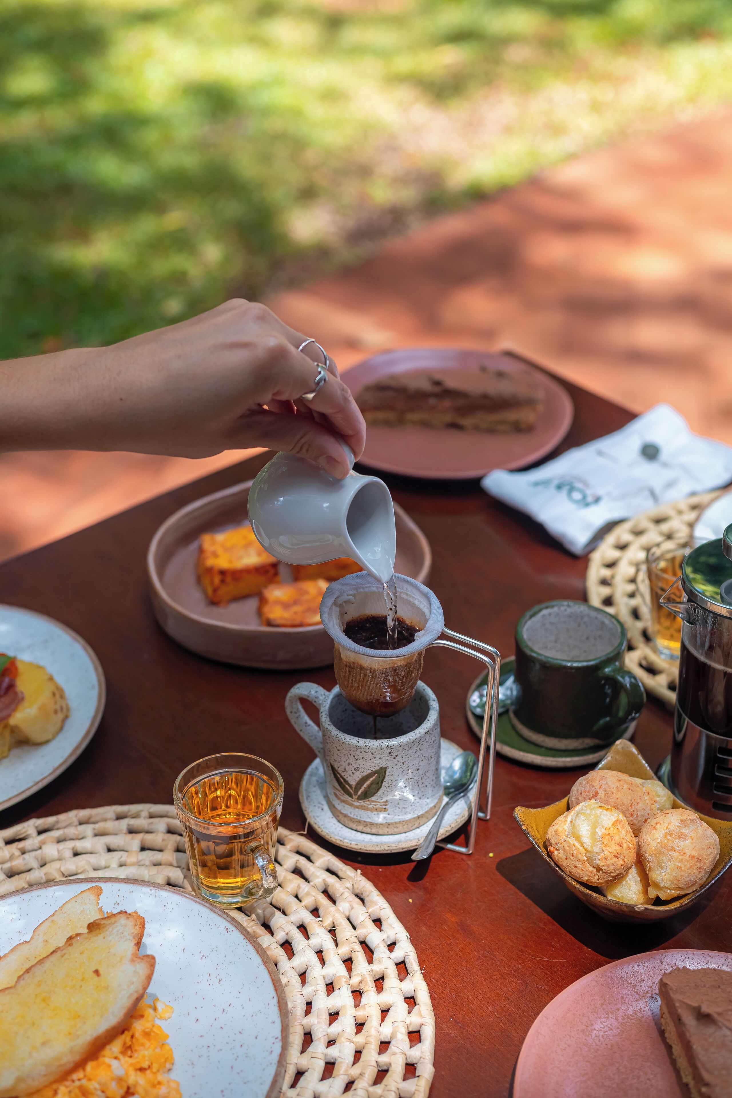 Mesa posta para o café da manhã, com diversos alimentos e bebidas.