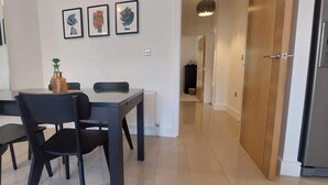 Ein Essbereich mit Tisch, Stühlen und Wandbildern.